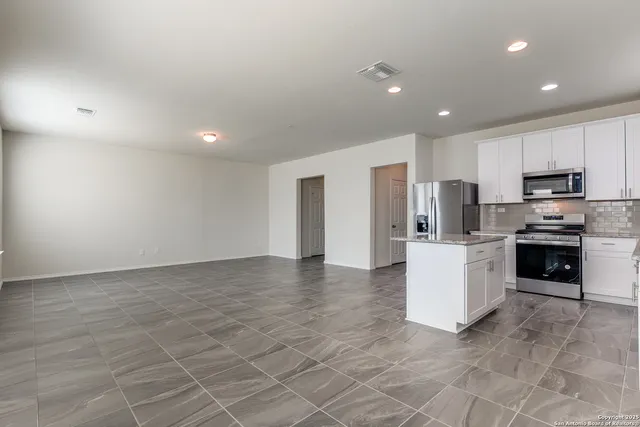 a kitchen with stainless steel appliances a refrigerator sink stove microwave and cabinets