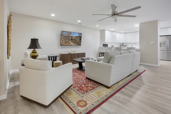 a living room with furniture kitchen view and a chandelier