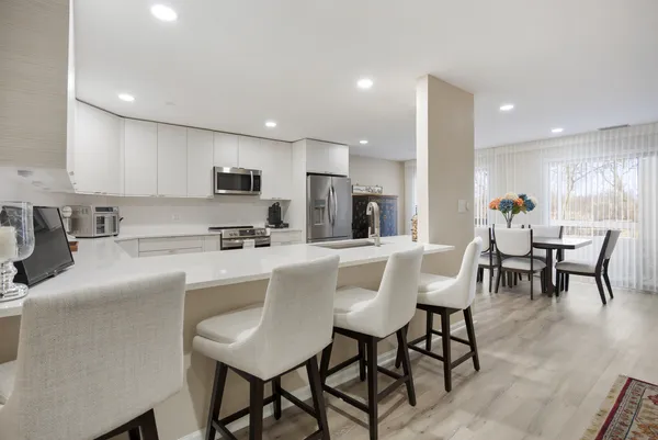 a kitchen with cabinets stainless steel appliances and wooden floor