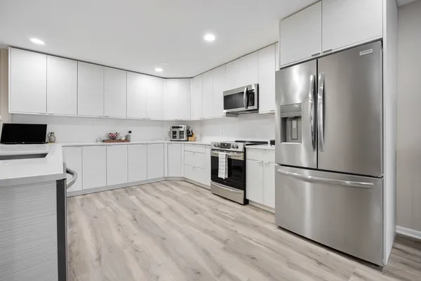 a kitchen with white cabinets and stainless steel appliances