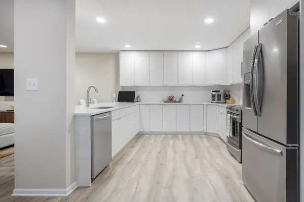 a kitchen with stainless steel appliances kitchen island sink refrigerator and microwave