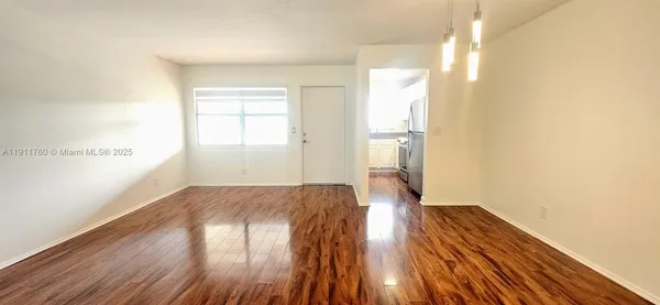 a view of empty room with wooden floor