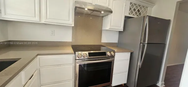 a kitchen with refrigerator and cabinets