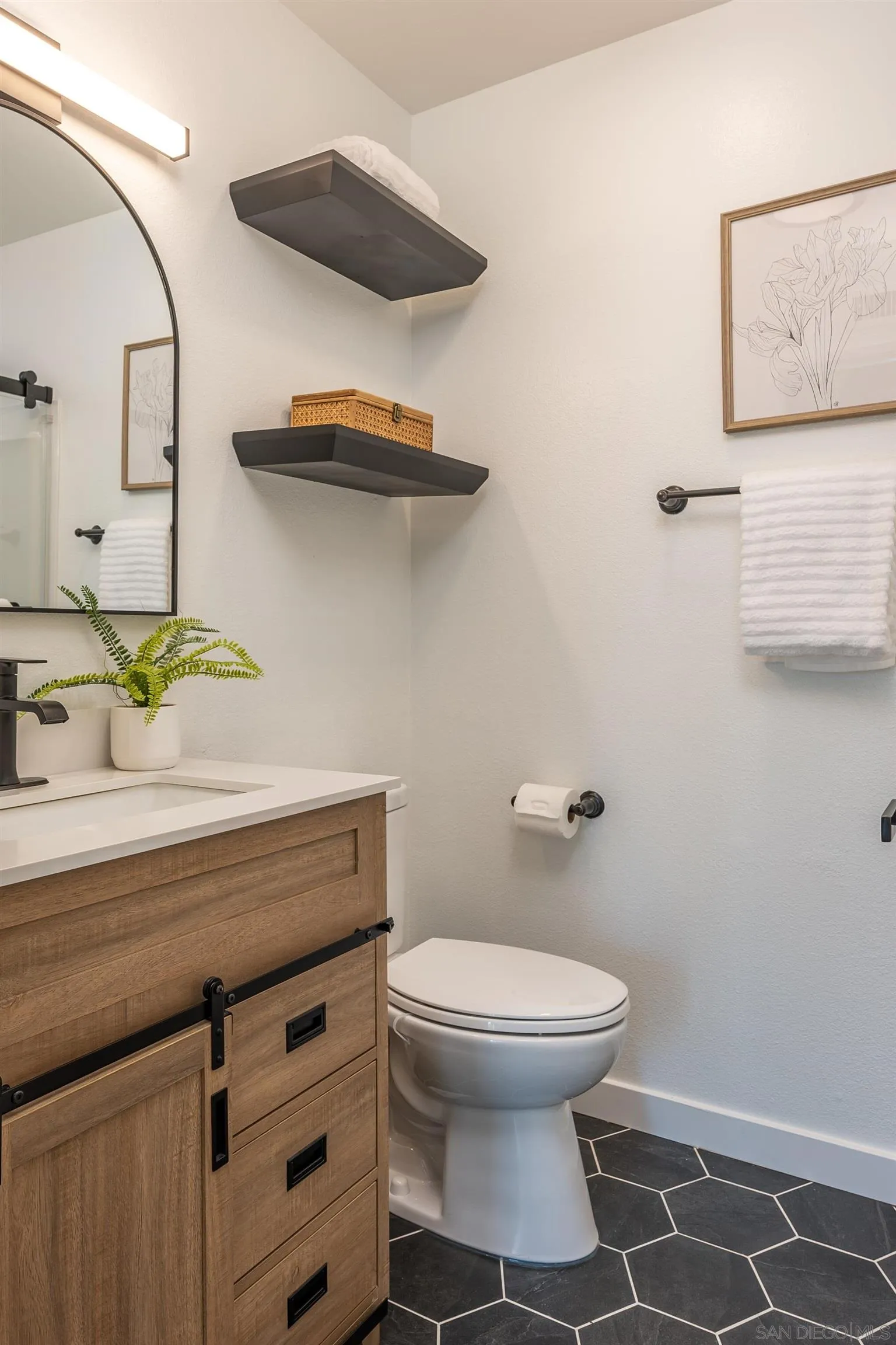 3577 Guava Way Oceanside, CA 92058 - Photo 16 of 42 a bathroom with a toilet and a mirror