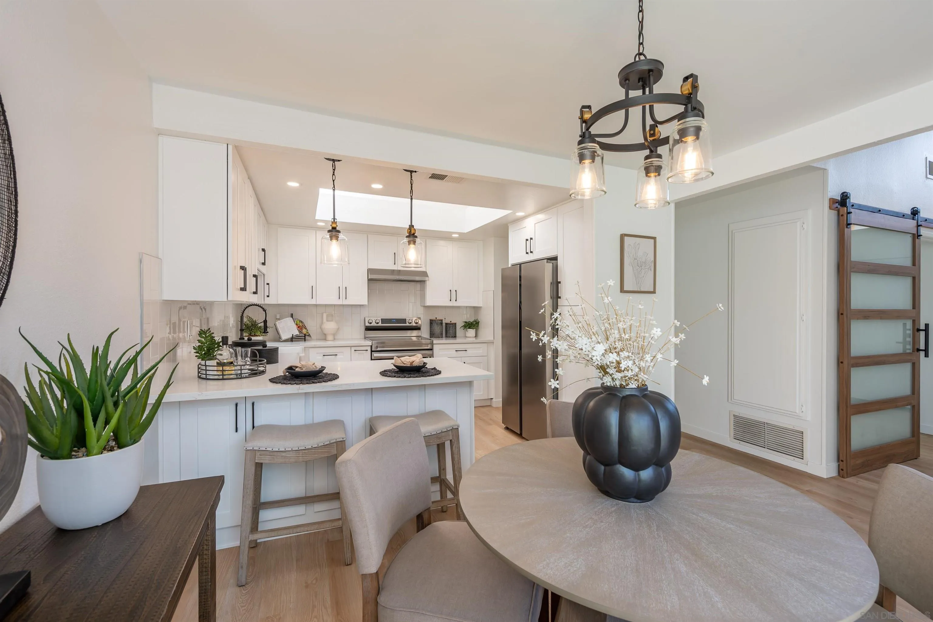 3577 Guava Way Oceanside, CA 92058 - Photo 7 of 42 a dining room with furniture a potted plant and a chandelier