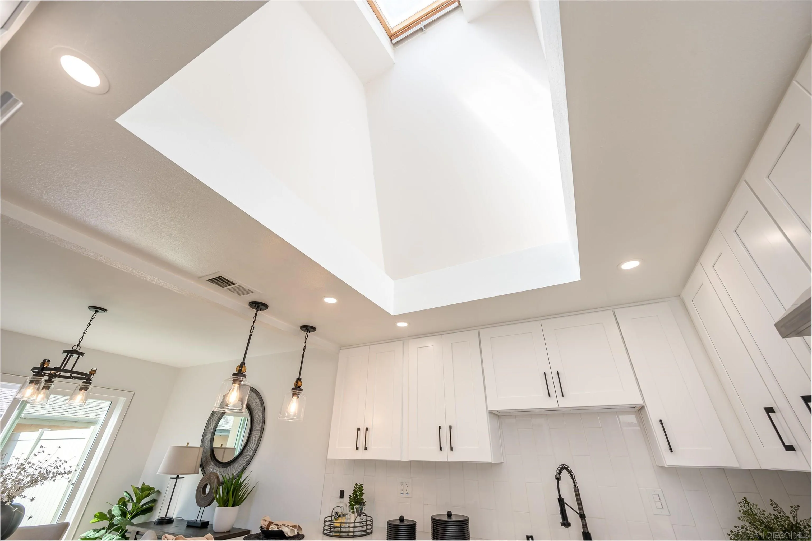 3577 Guava Way Oceanside, CA 92058 - Photo 10 of 42 a large kitchen with a lot of cabinets and a clock