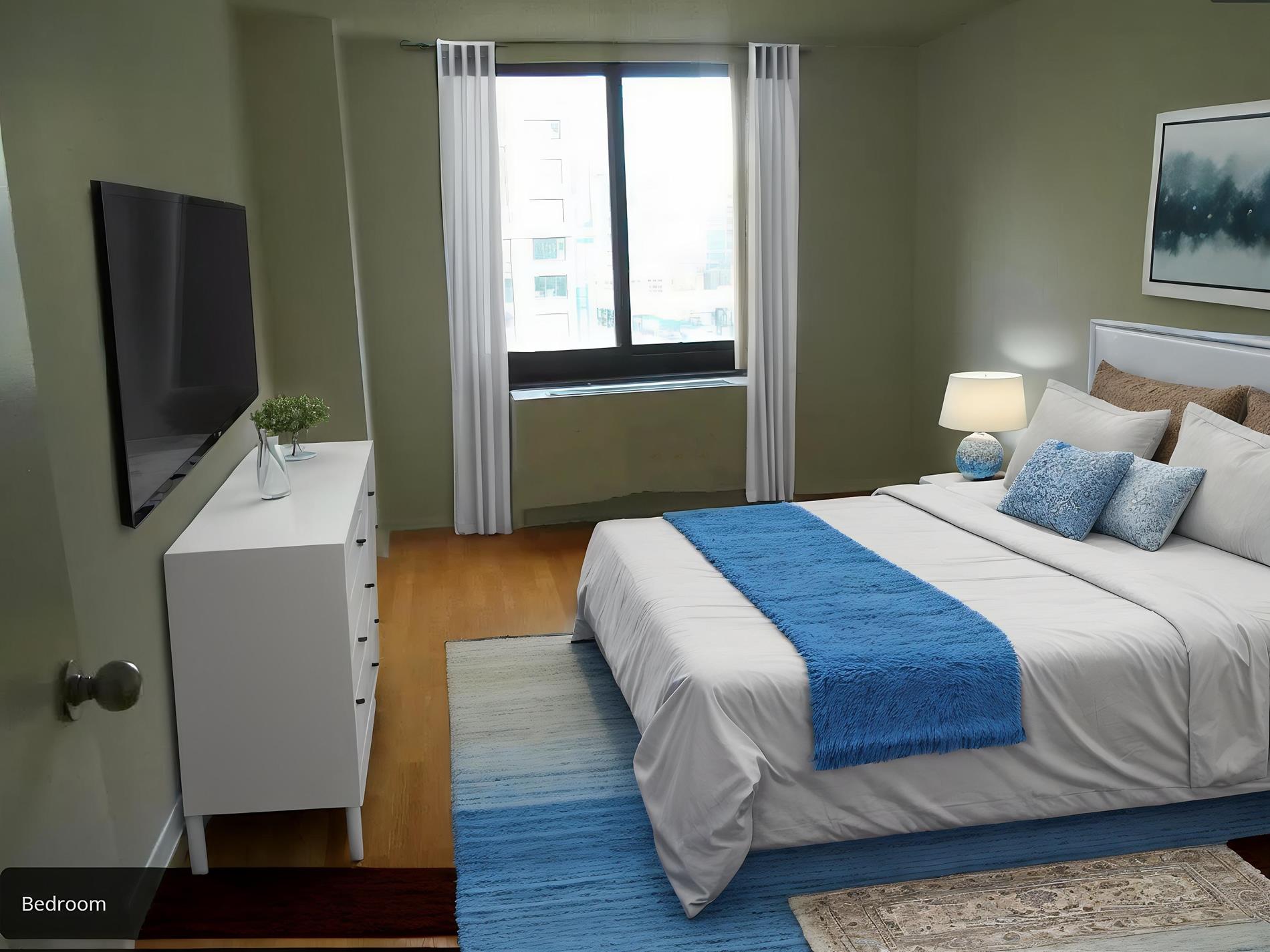 a bedroom with a bed and a flat tv screen on dresser