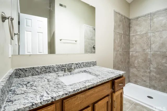 a bathroom with a granite countertop sink and a bathtub