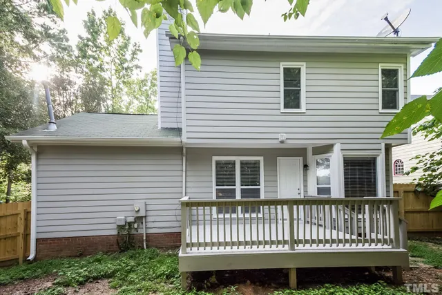 a view of a house with a yard and a large tree