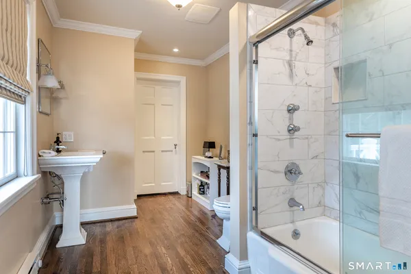 a bathroom with a sink a toilet and shower