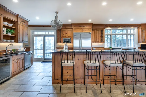 a kitchen with stainless steel appliances granite countertop a stove a sink and a refrigerator