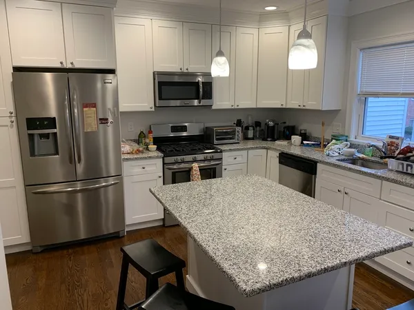 a kitchen with stainless steel appliances granite countertop a sink stove and refrigerator