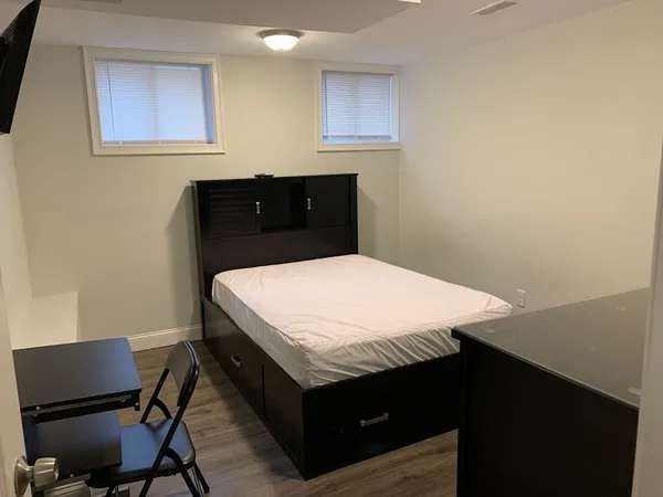 a bed sitting in a bedroom next to a window