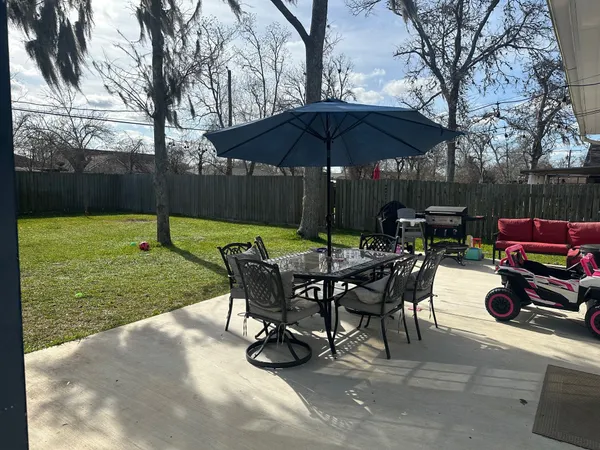 a view of a backyard with table and chairs under an umbrella