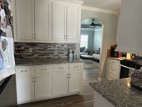 a kitchen with granite countertop a sink and cabinets