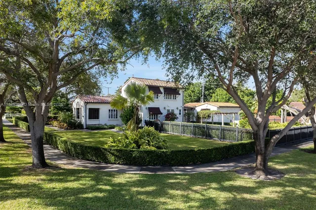 a view of house with swimming pool and a yard
