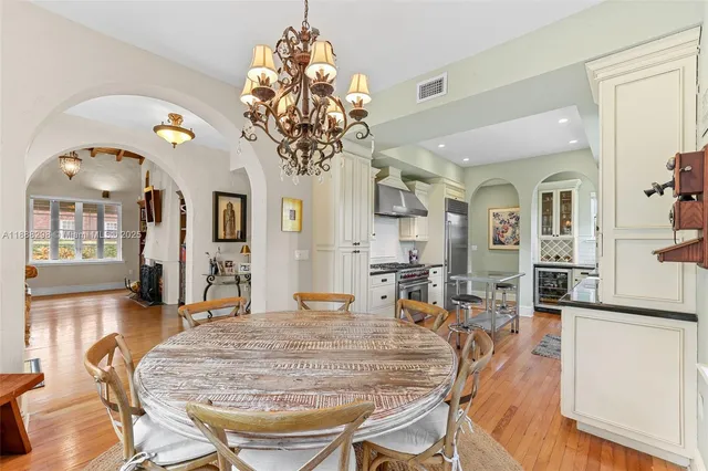 a view of a dining room with furniture a chandelier and wooden floor