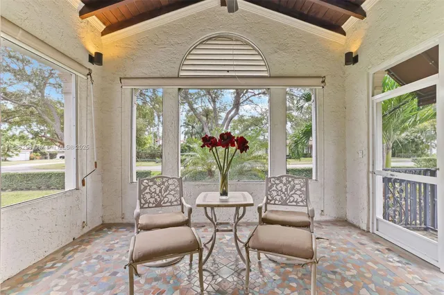 a dining room with furniture a chandelier and glass door