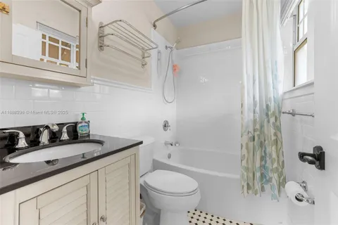 a bathroom with a granite countertop sink a toilet and shower