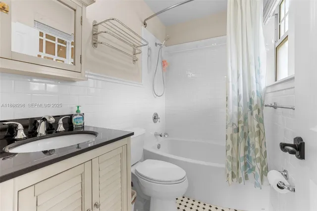 a bathroom with a granite countertop sink a toilet and shower