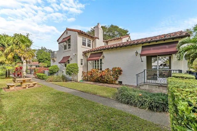 a front view of a house with a garden and plants