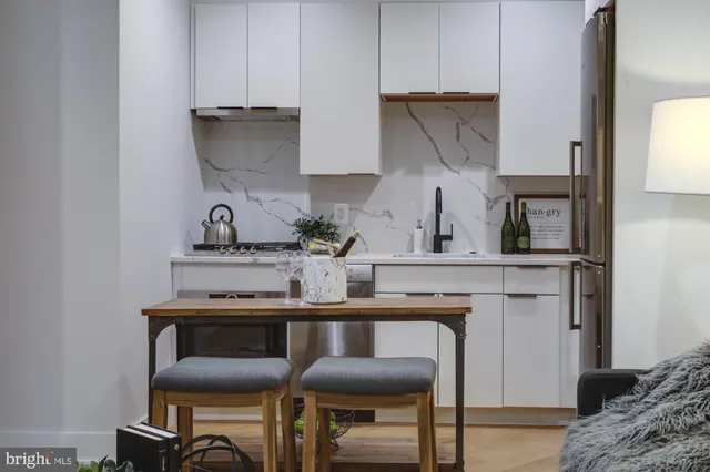a kitchen with a table chairs and a refrigerator