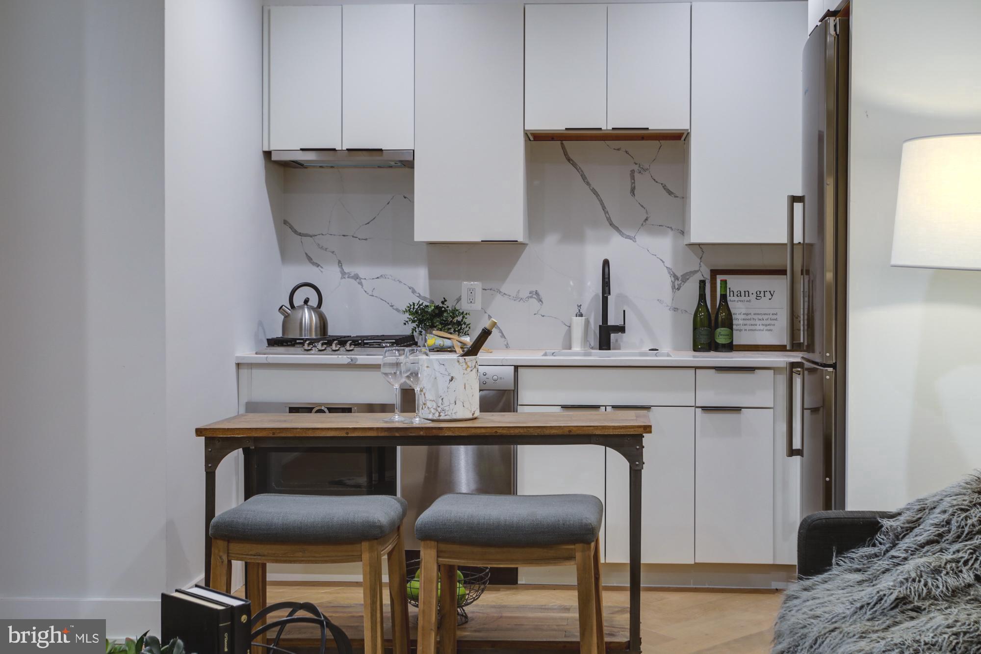 1225 11th Street Northwest, Unit A Washington, DC 20001 - Photo 3 of 18 a kitchen with a table chairs and a refrigerator