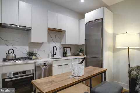 a kitchen with a sink a refrigerator and cabinets