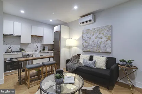 a living room with furniture and a dining table with wooden floor