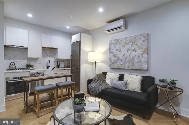 a living room with furniture and a dining table with wooden floor