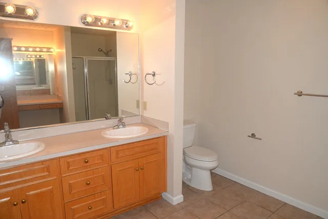 a bathroom with a granite countertop sink toilet and shower