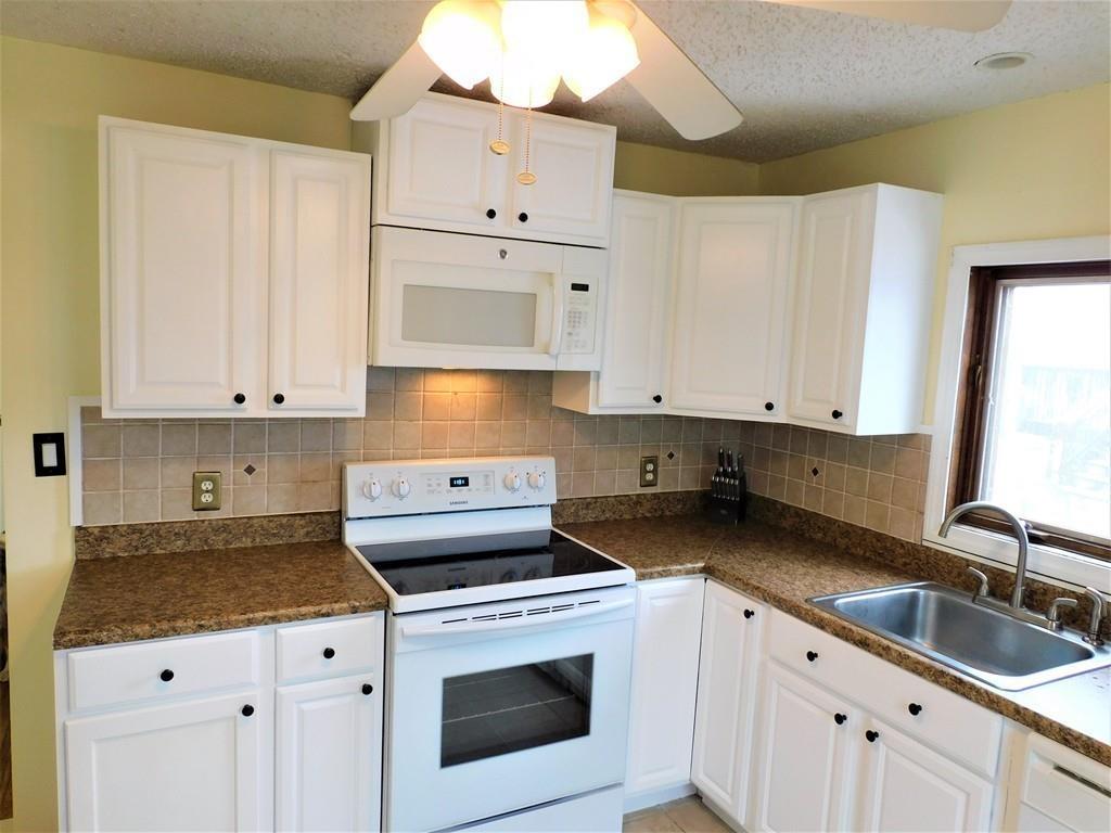 94 Surrey Road Springfield, MA 01118 - Photo 17 of 36 a kitchen with granite countertop white cabinets and white appliances