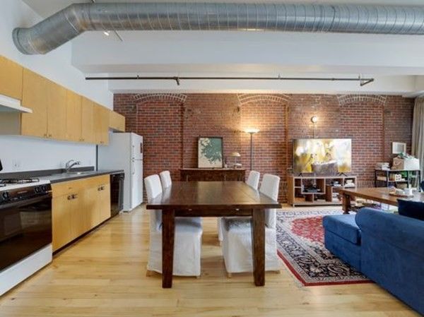 a kitchen with stainless steel appliances granite countertop a table chairs sink and cabinets