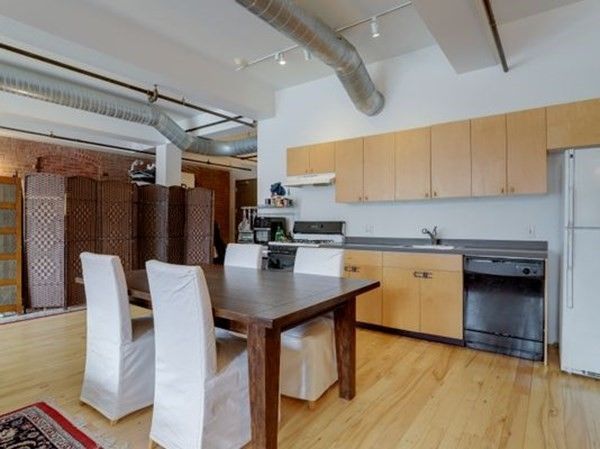 a living room with couches a table and chairs with wooden floor