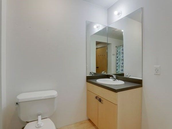 a bed sitting in a spacious bedroom next to a window