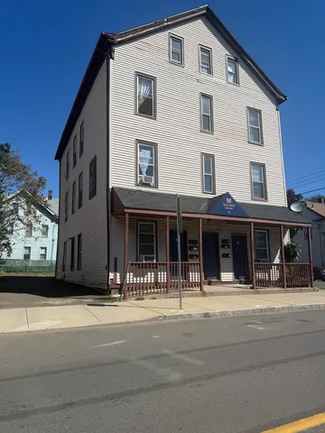 a front view of a house with a tree