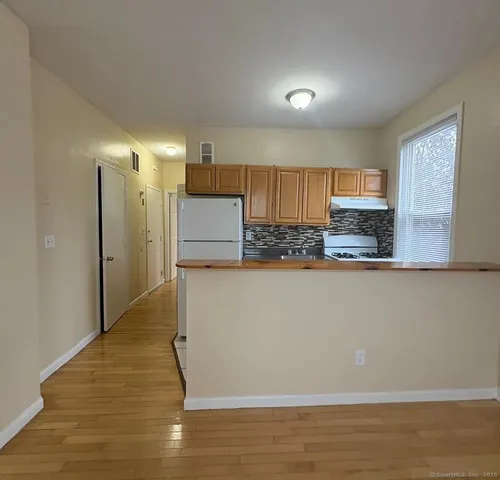 a kitchen with stainless steel appliances granite countertop a refrigerator and a stove top oven