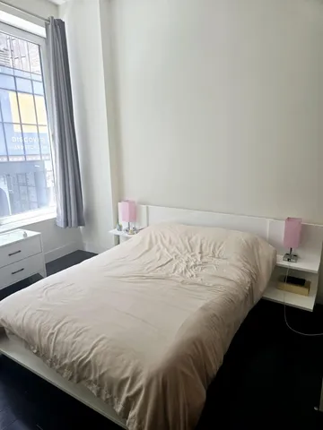 a bedroom with a bed and a window