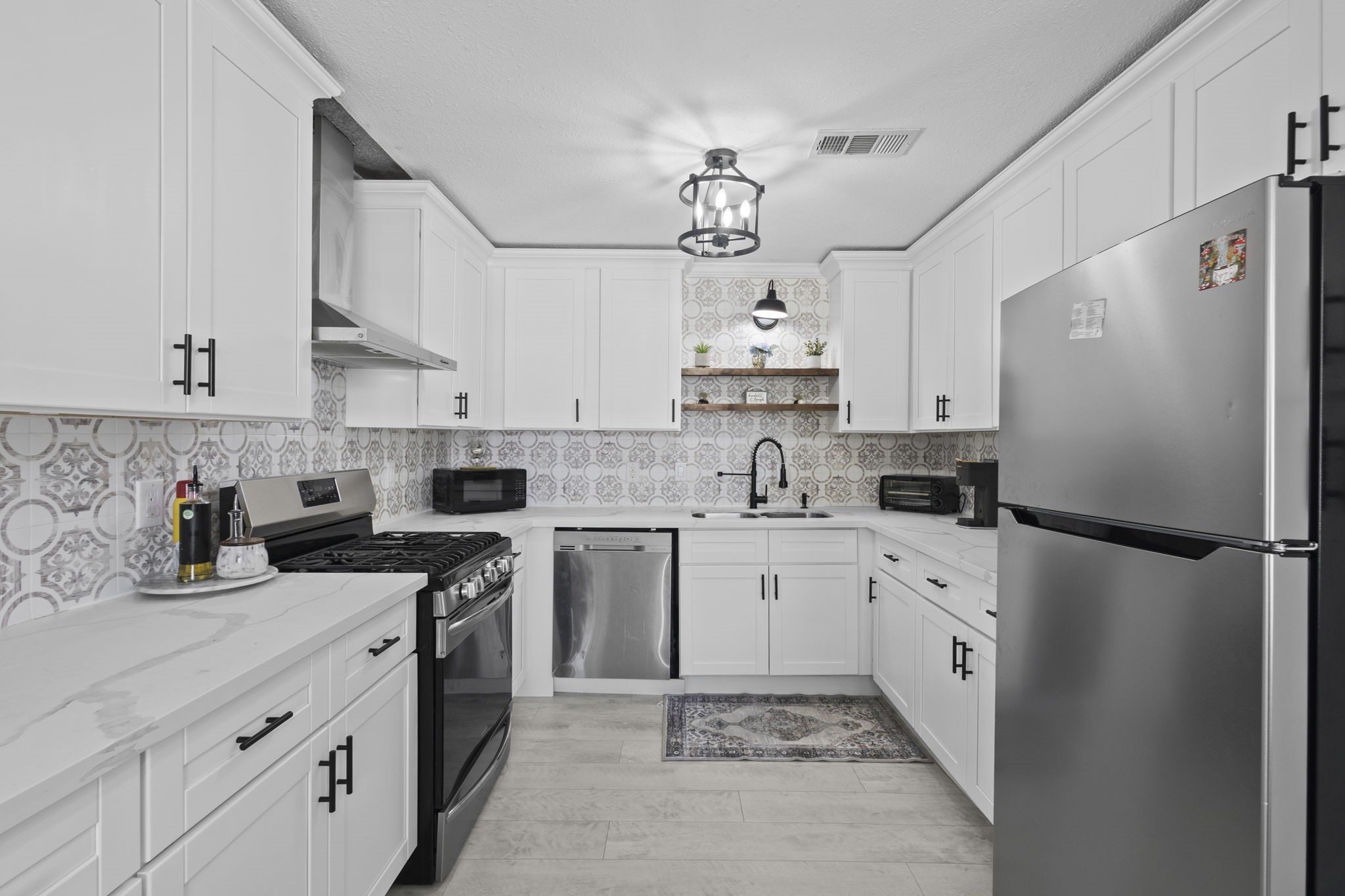 1006 Montgomery Street Port Neches, TX 77651 - Photo 8 of 29 a kitchen with stainless steel appliances granite countertop a sink a stove a refrigerator and white cabinets
