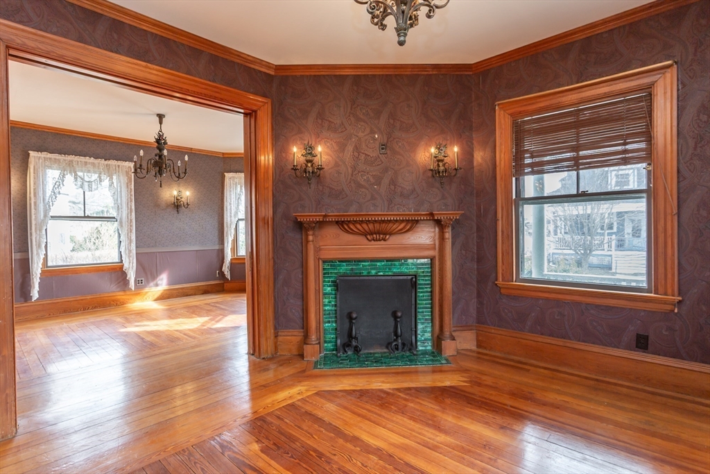 445 Madison Street Fall River, MA 02720 - Photo 6 of 42 a view of a livingroom with wooden floor and a fireplace