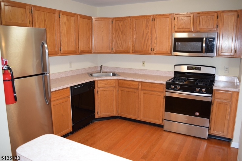 250 Potomac Drive Bernards, NJ 07920 - Photo 4 of 22 a kitchen with stainless steel appliances a refrigerator stove top oven and sink
