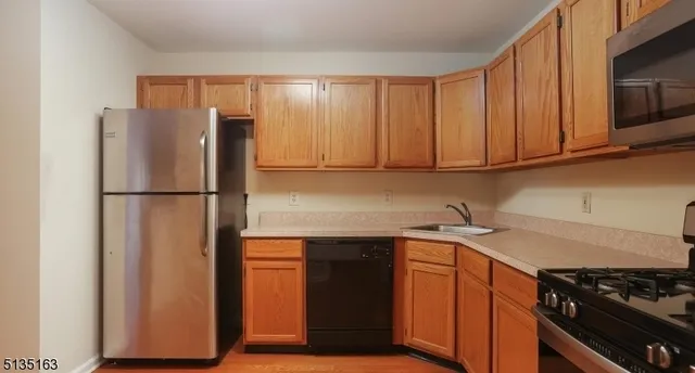 a kitchen with stainless steel appliances granite countertop a refrigerator and a stove top oven