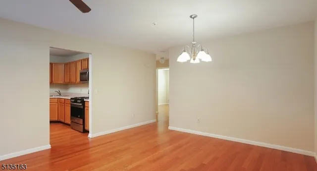 a view of a kitchen with stainless steel appliances granite countertop a sink a stove a refrigerator and a window