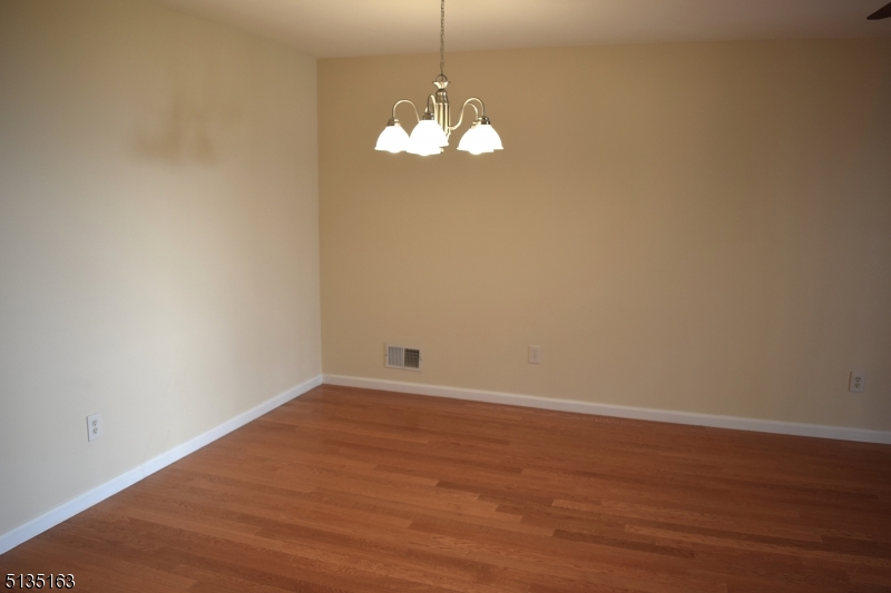 250 Potomac Drive Bernards, NJ 07920 - Photo 8 of 22 a view of a chandelier fan wooden floor and windows
