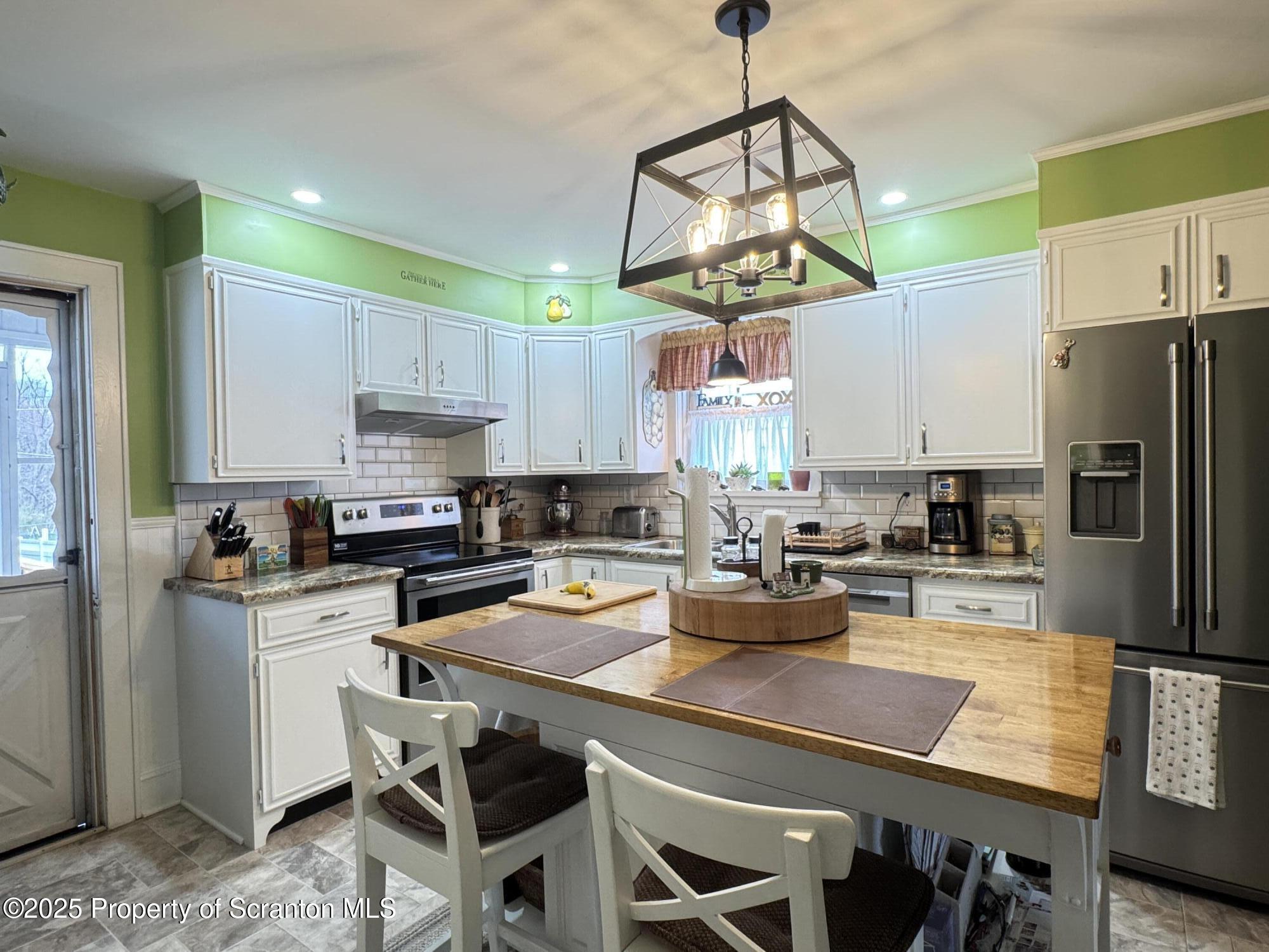954 Lattimer Road Hazleton, PA 18202 - Photo 6 of 16 a kitchen with a table chairs refrigerator and microwave