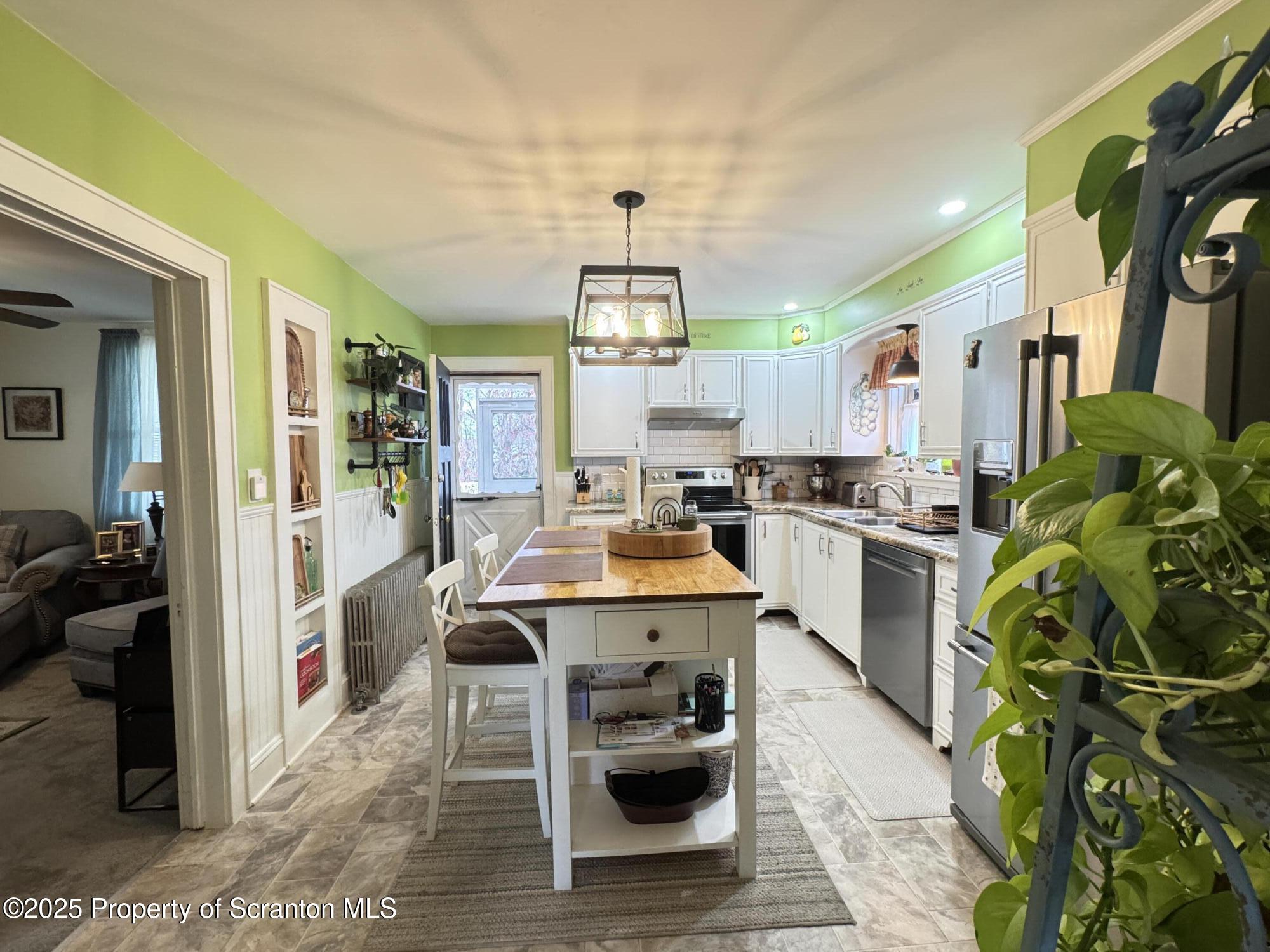 954 Lattimer Road Hazleton, PA 18202 - Photo 7 of 16 a kitchen with stainless steel appliances kitchen island granite countertop a refrigerator a stove a sink dishwasher and white cabinets with wooden floor