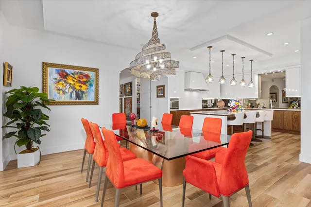 a dining room with furniture a chandelier and wooden floor