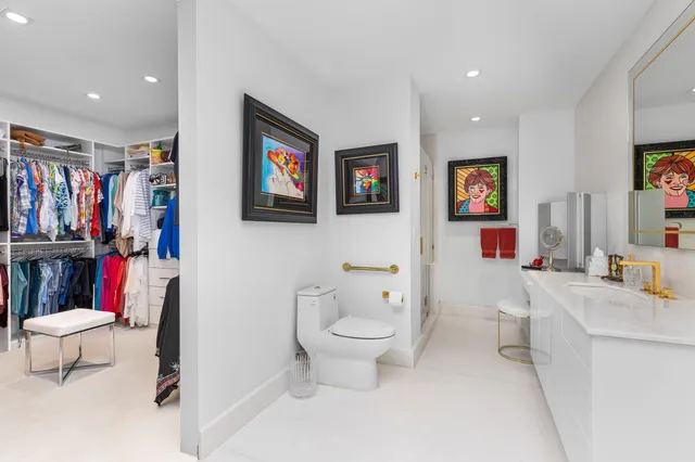 a bathroom with a toilet sink and a large mirror
