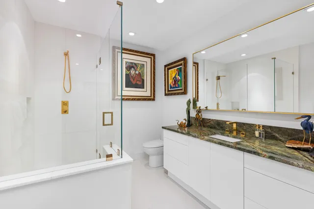 a bathroom with a granite countertop sink mirror and toilet