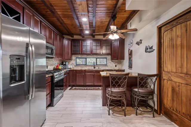 a kitchen with stainless steel appliances granite countertop a stove a sink a refrigerator and island